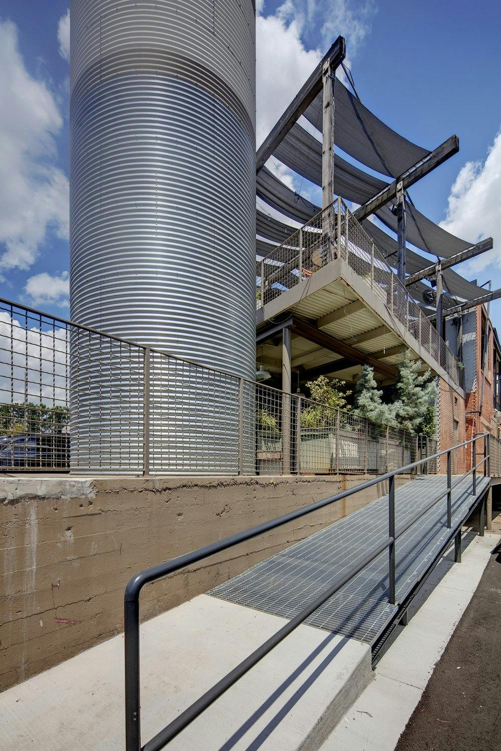 A building with a metal walkway and a metal silo.