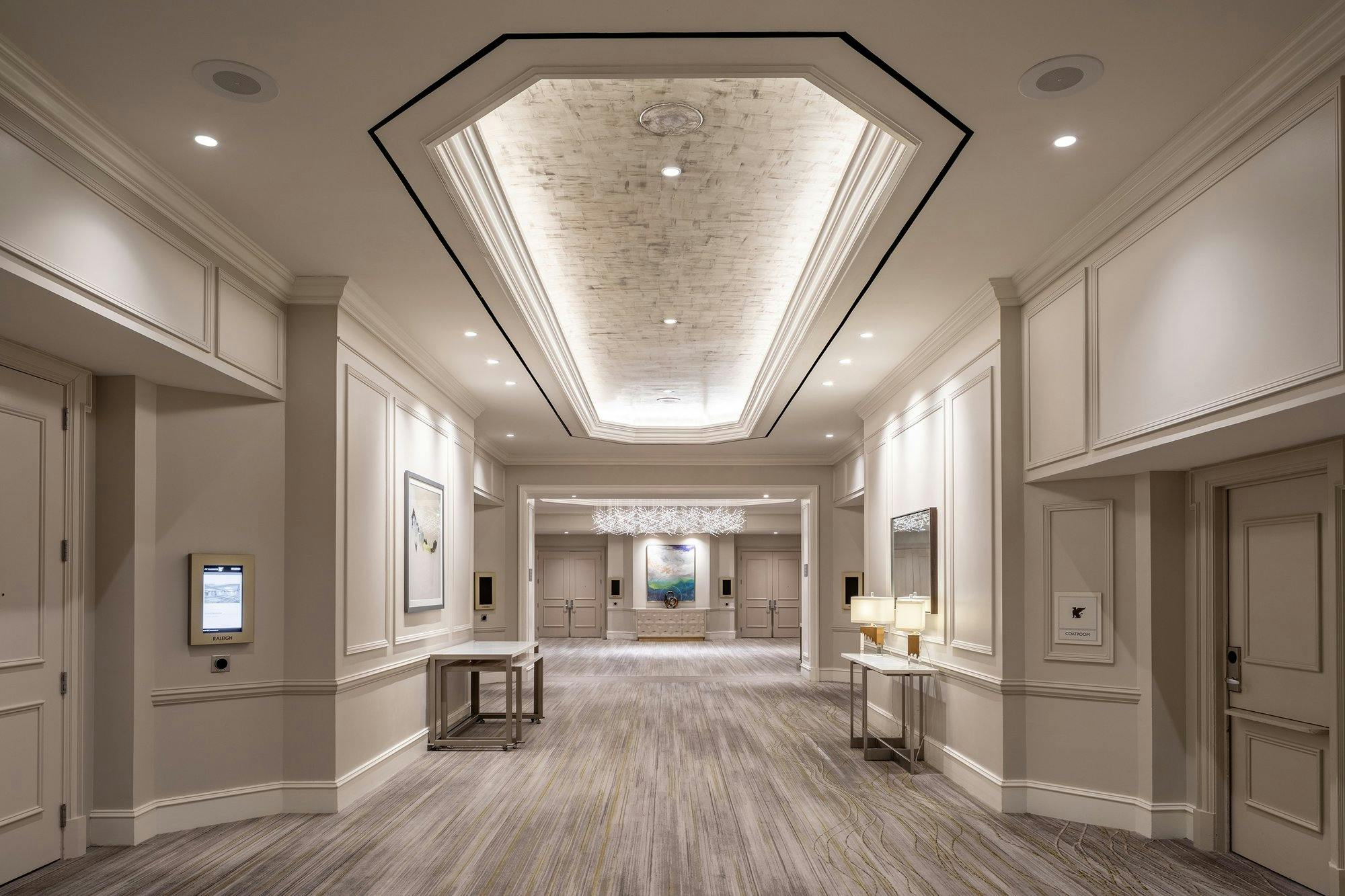 A hallway in a hotel with a ceiling light.