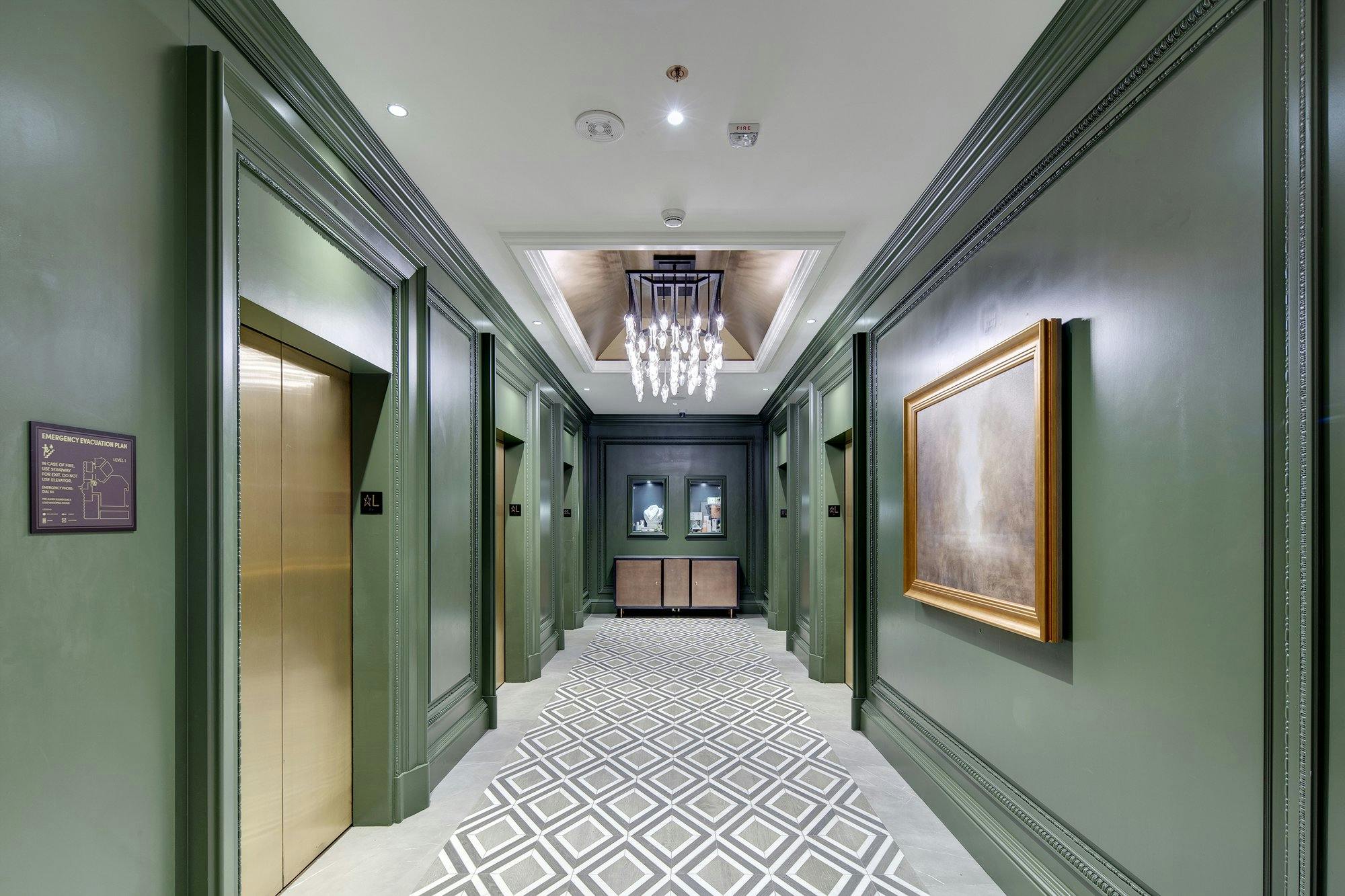 Elevator lobby with green walls and brass elevator doors.