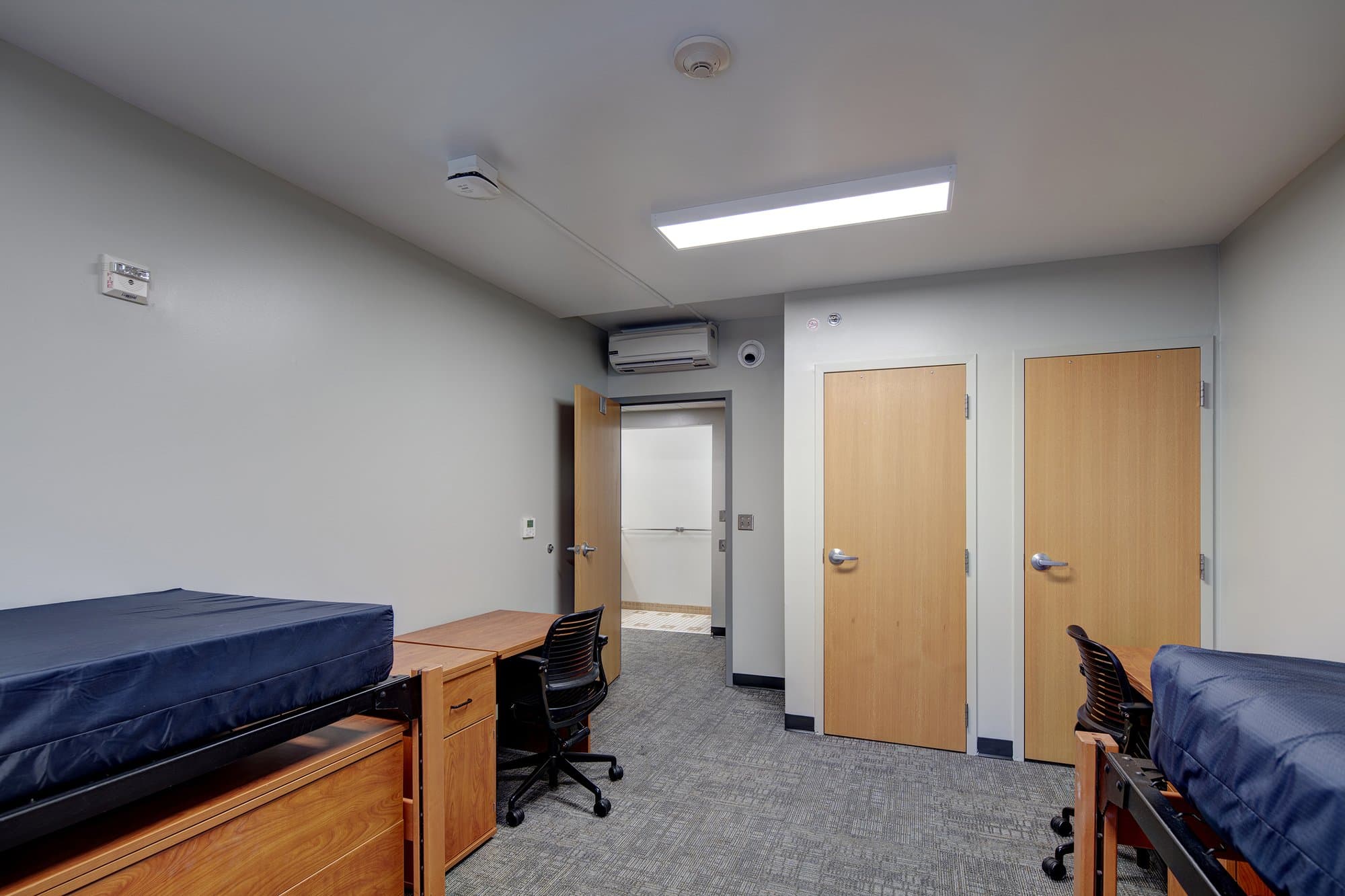 Sorority bedroom with 2 beds and two desks.