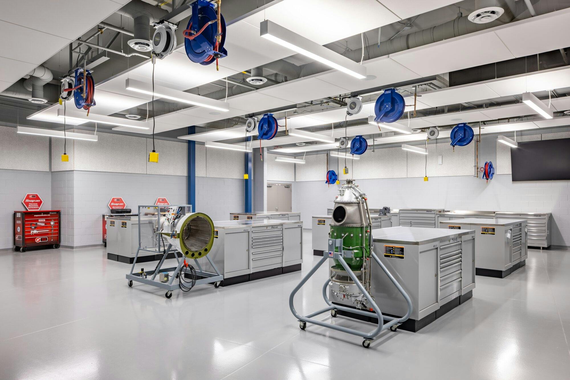 Hands on classroom environment with work tables, machinery and pendant drop outlets at each work station.