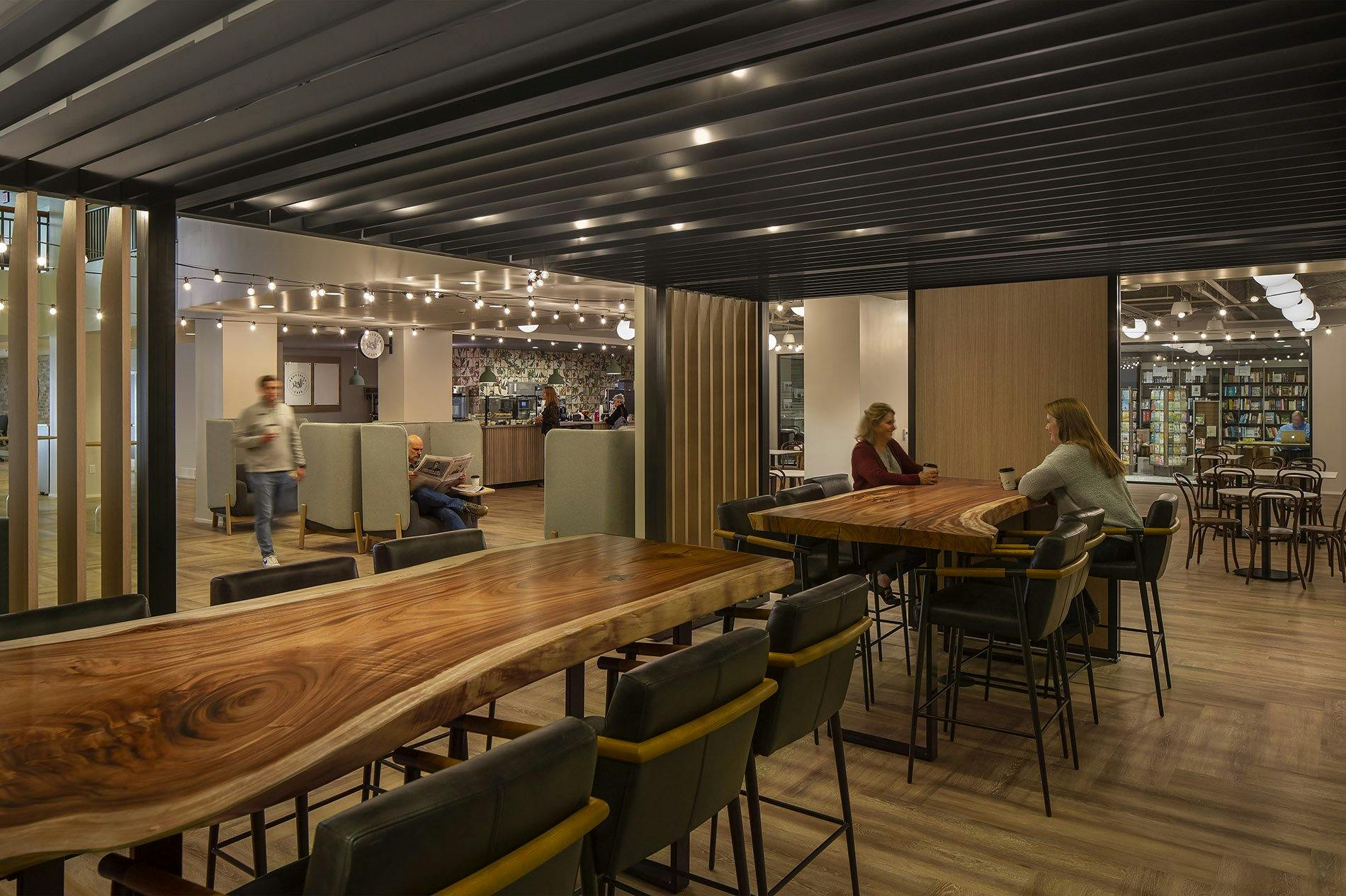 dining area with large wooden tables and stools for seating