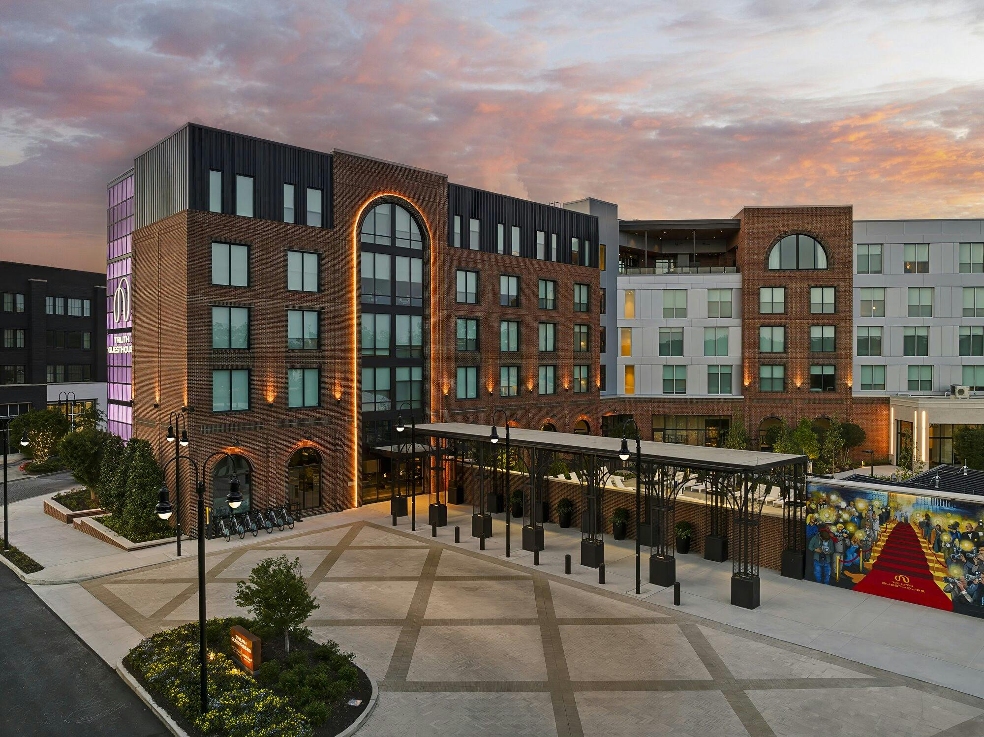 Back entrance of hotel featuring unique lighted window entire length of building and curved at top.