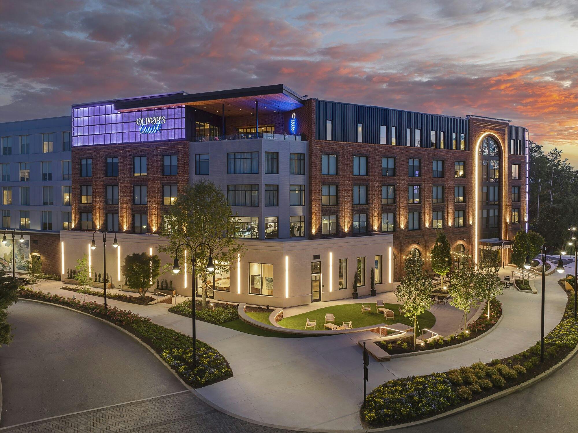 Exterior rendering of luxurious hotel with purple lighted sign on the side. With view of rooftop bar.