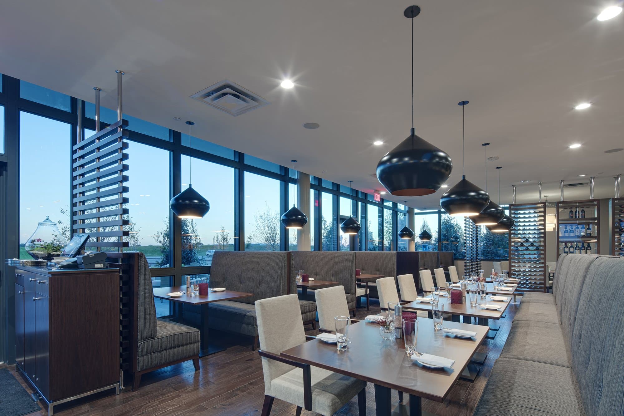 Modern restaurant seating with large windows in the background. 