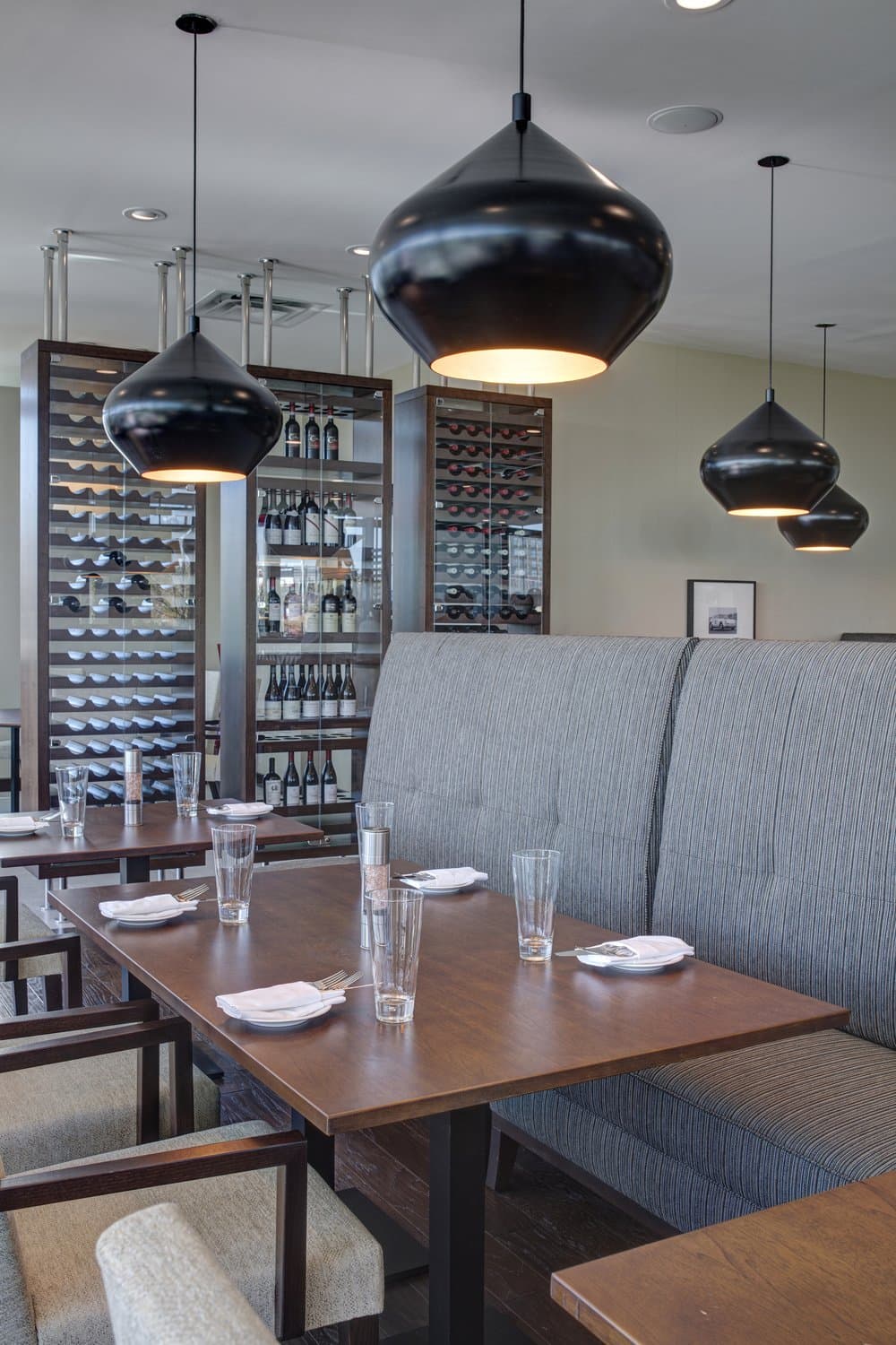 Restaurant booth seating with overhanging black pendant lights.