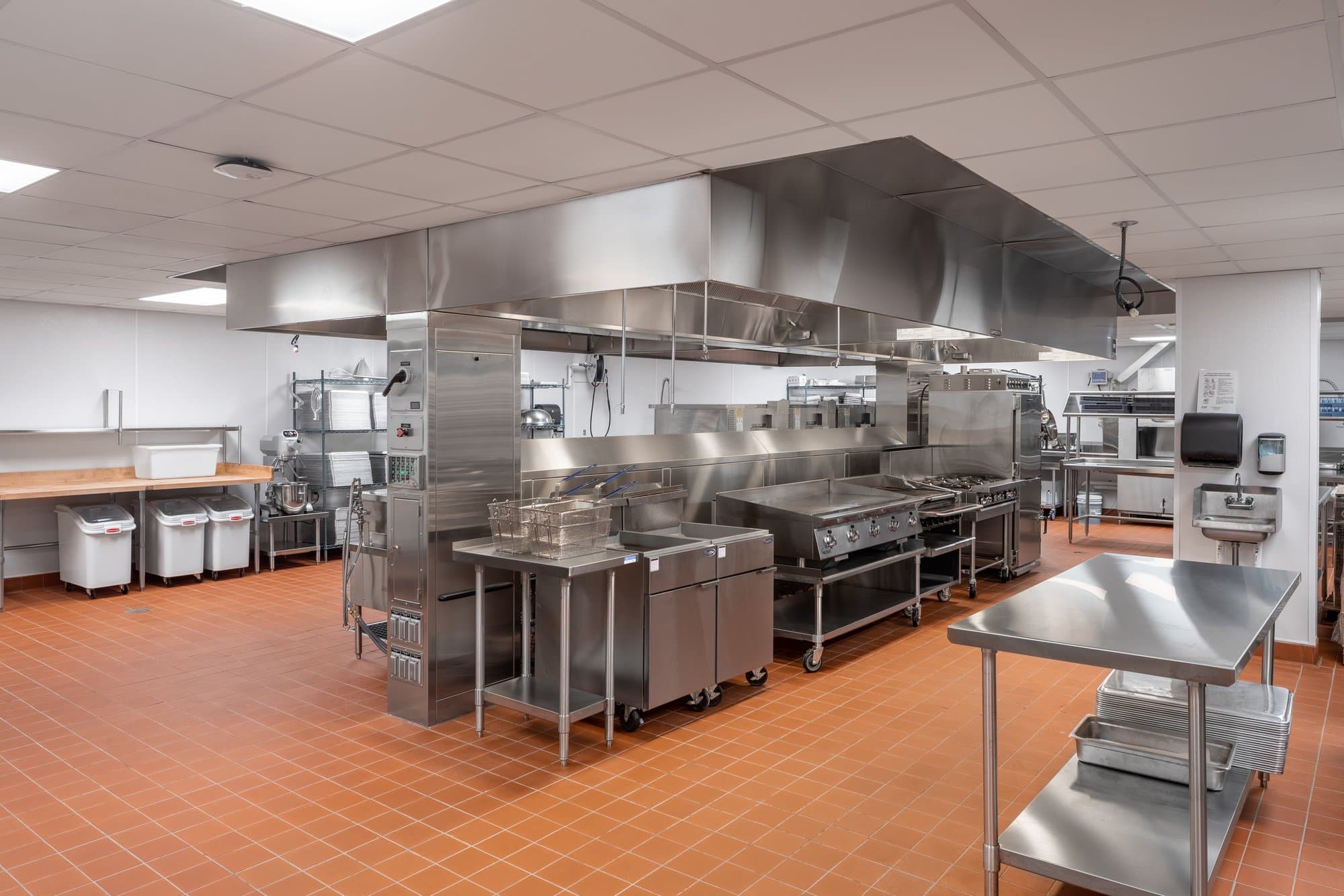 large commercial kitchen with multiple grills and other appliance in the center of the room for ease of access