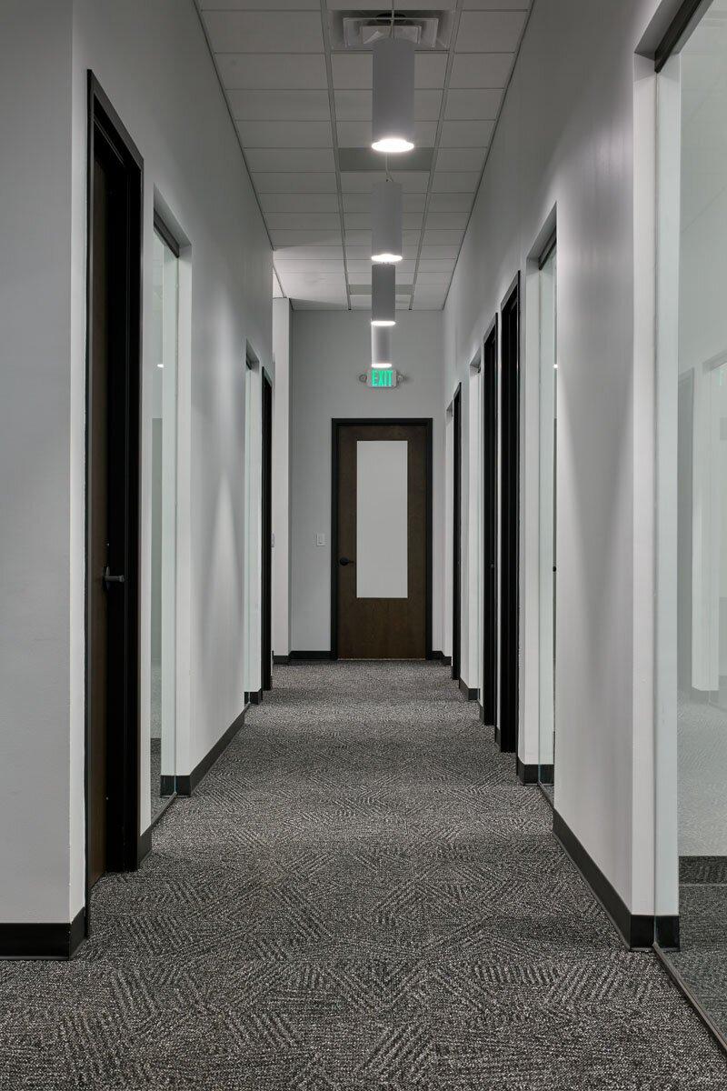 A hallway leading from the warehouse with multiple doors opening up to office spaces.