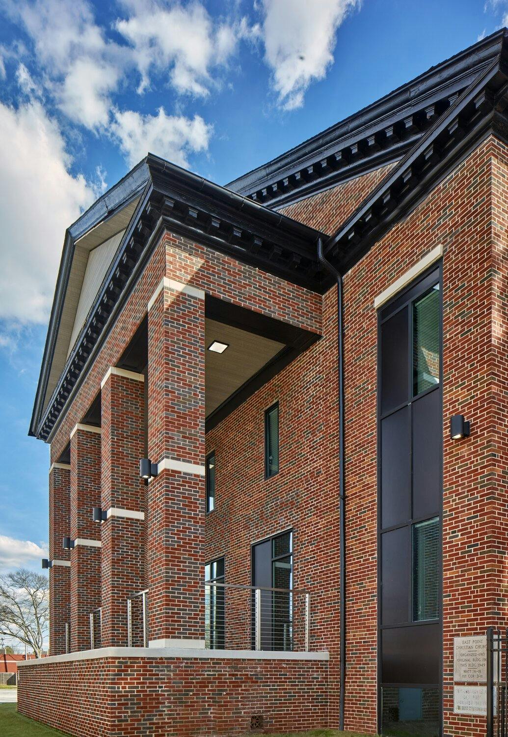 Brick facade entrance to the school featuring square columns and black cornice detailing.