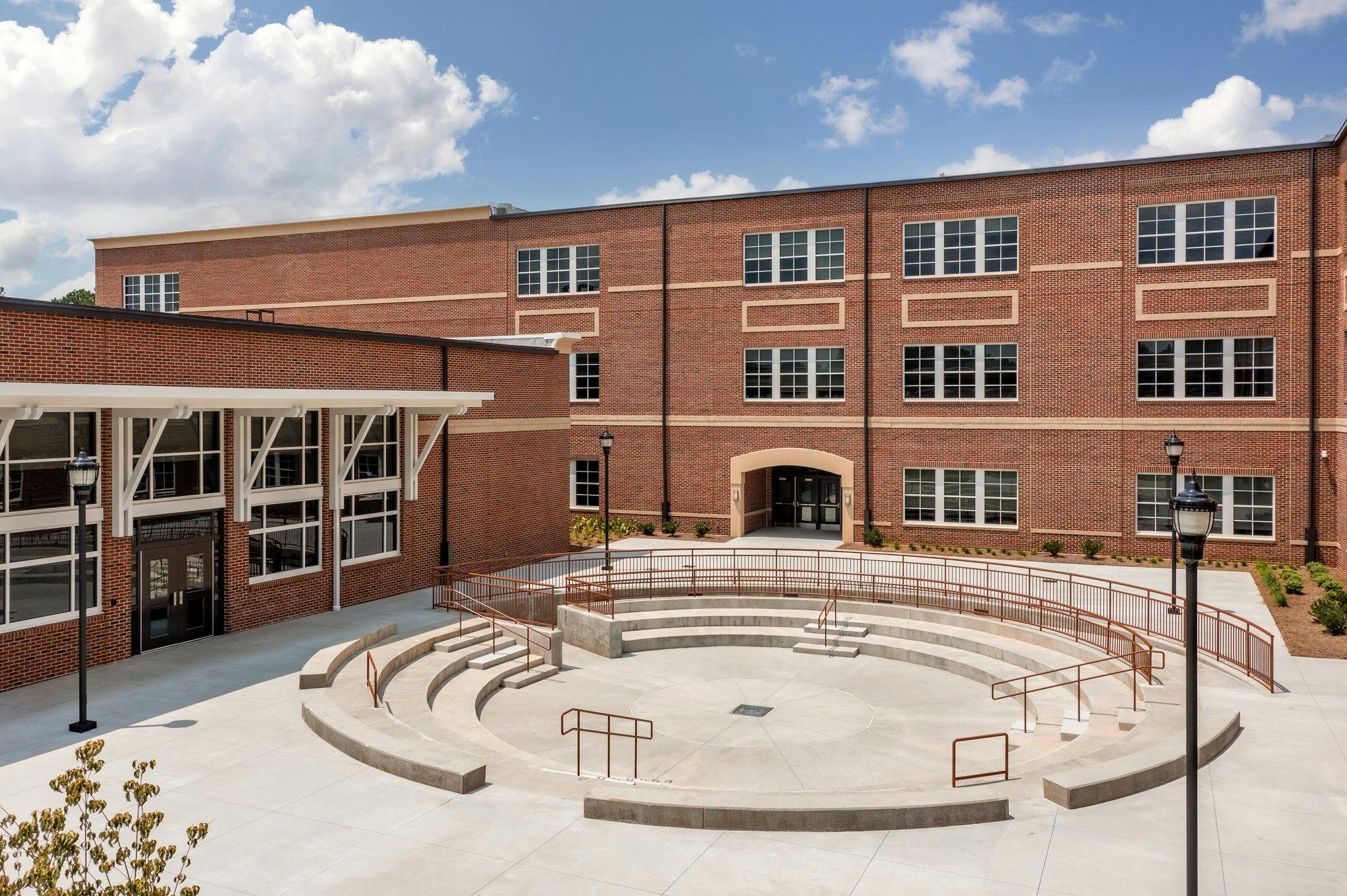 A circular concrete amphitheater is flanked by the brick exterior of Indian Creek Elementary School. 