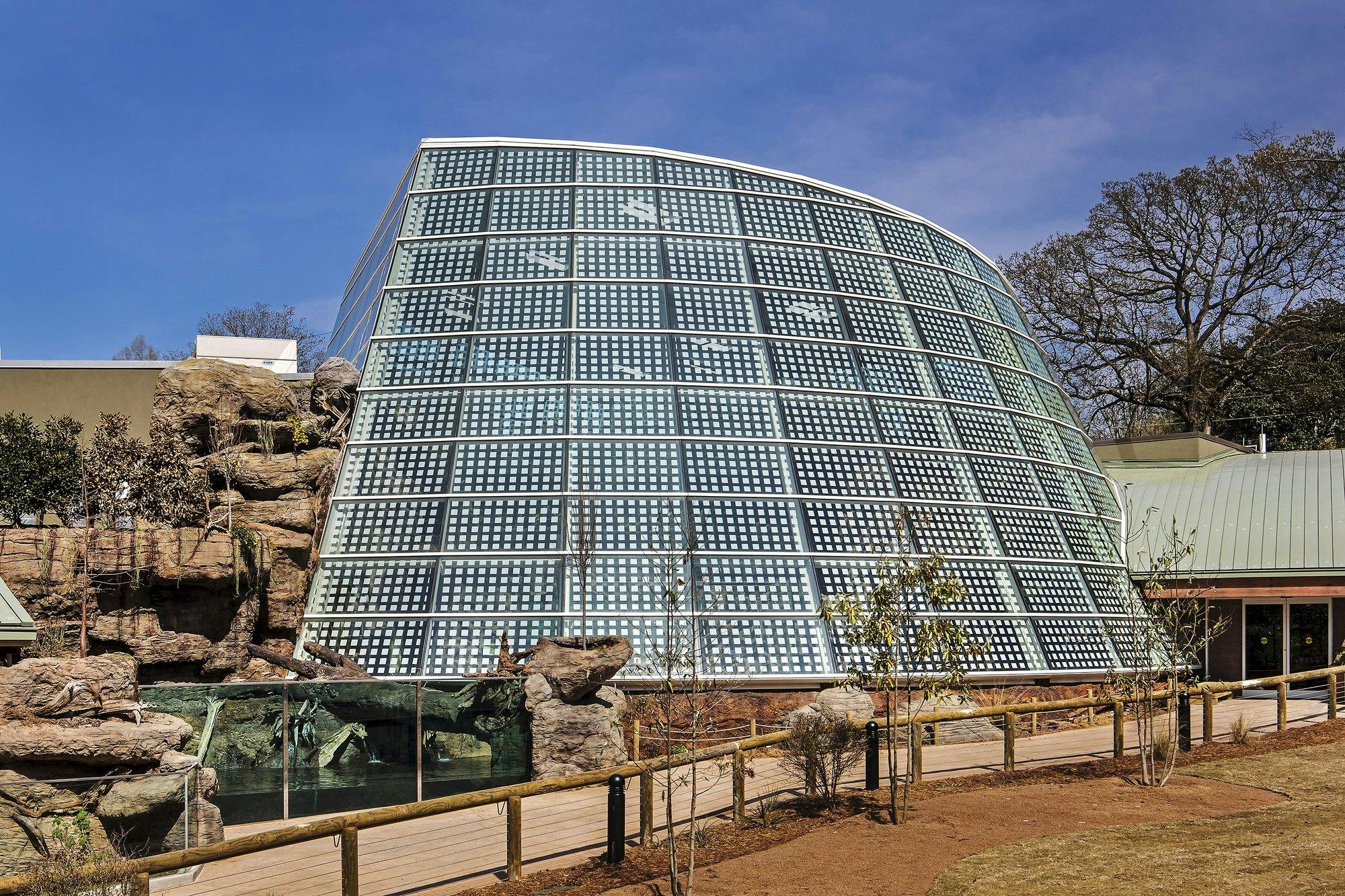 A reptile exhibit at a zoo with a glass roof. 	