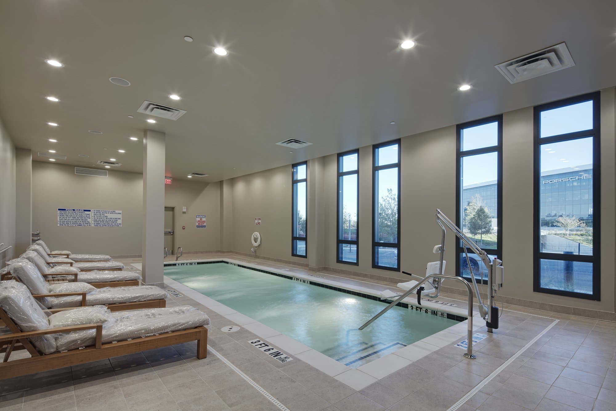 Indoor hotel pool with lounge chairs.