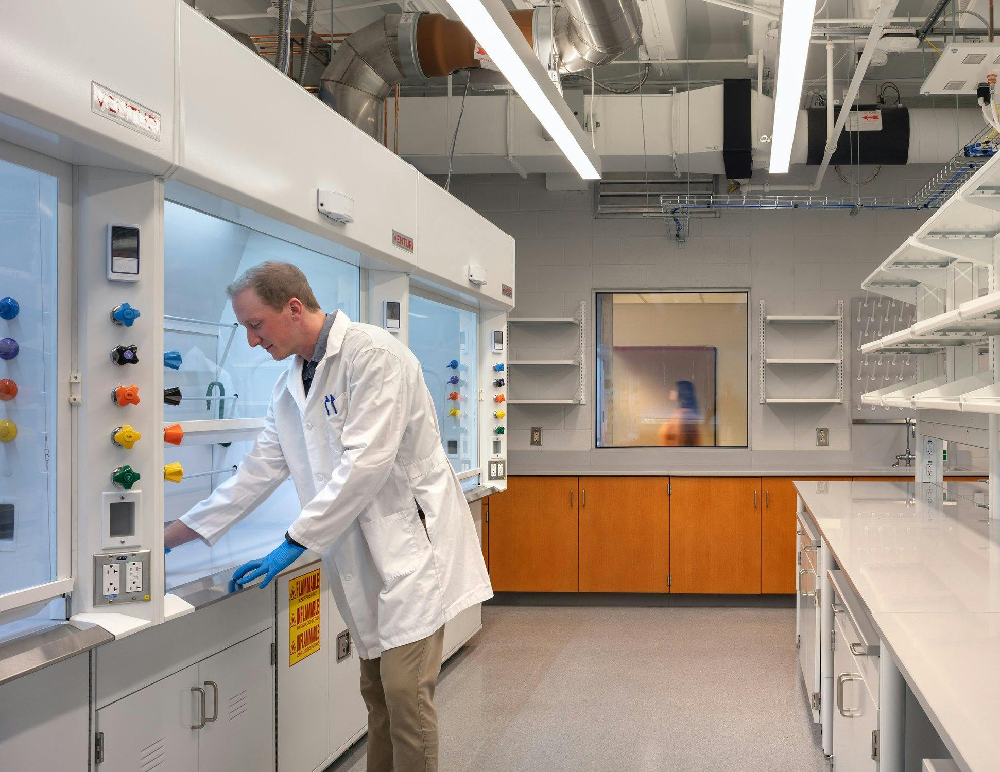 Lab technician adding samples to a sterile hood