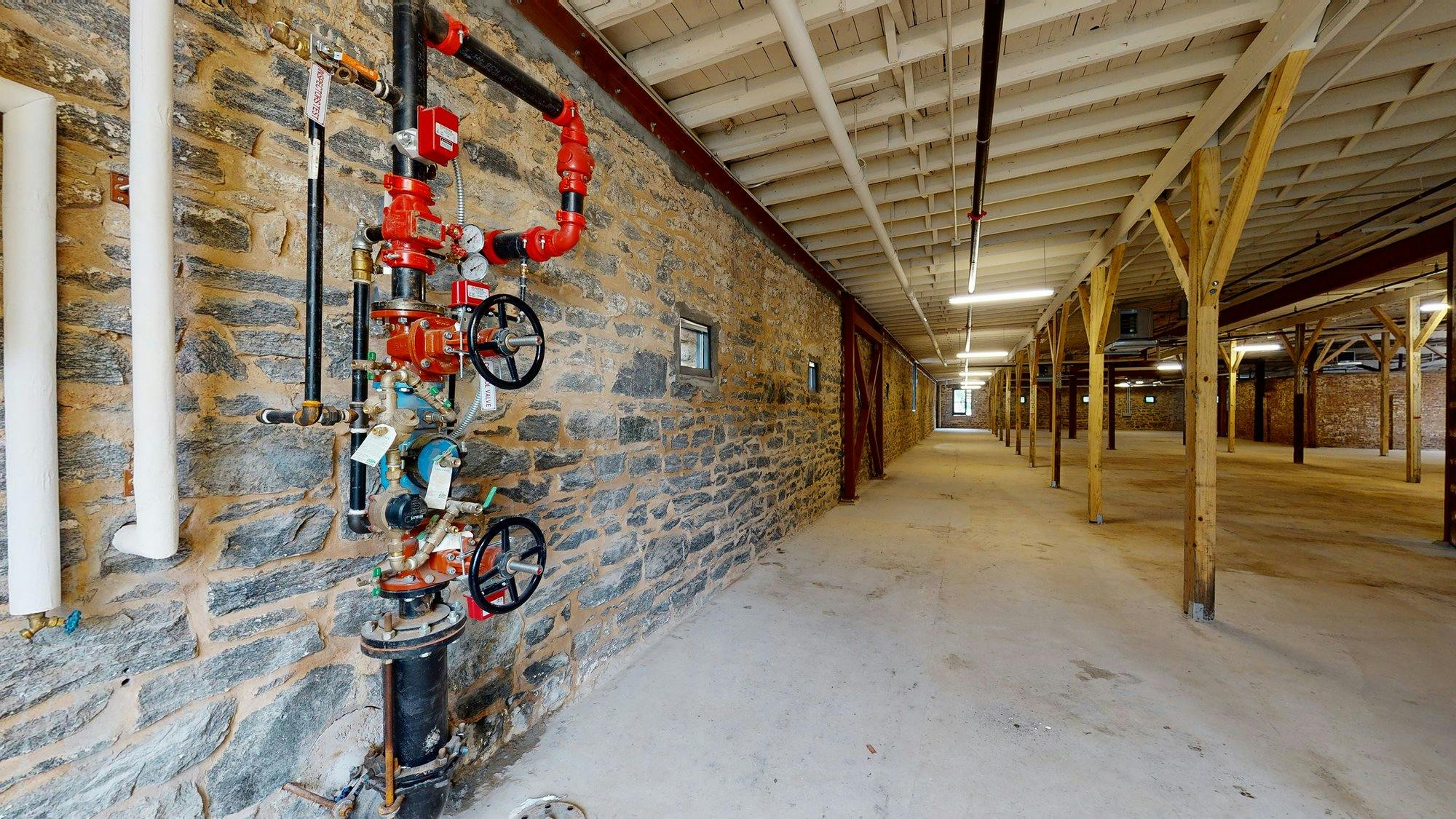 Historic stables with a fire hydrant and pipes.