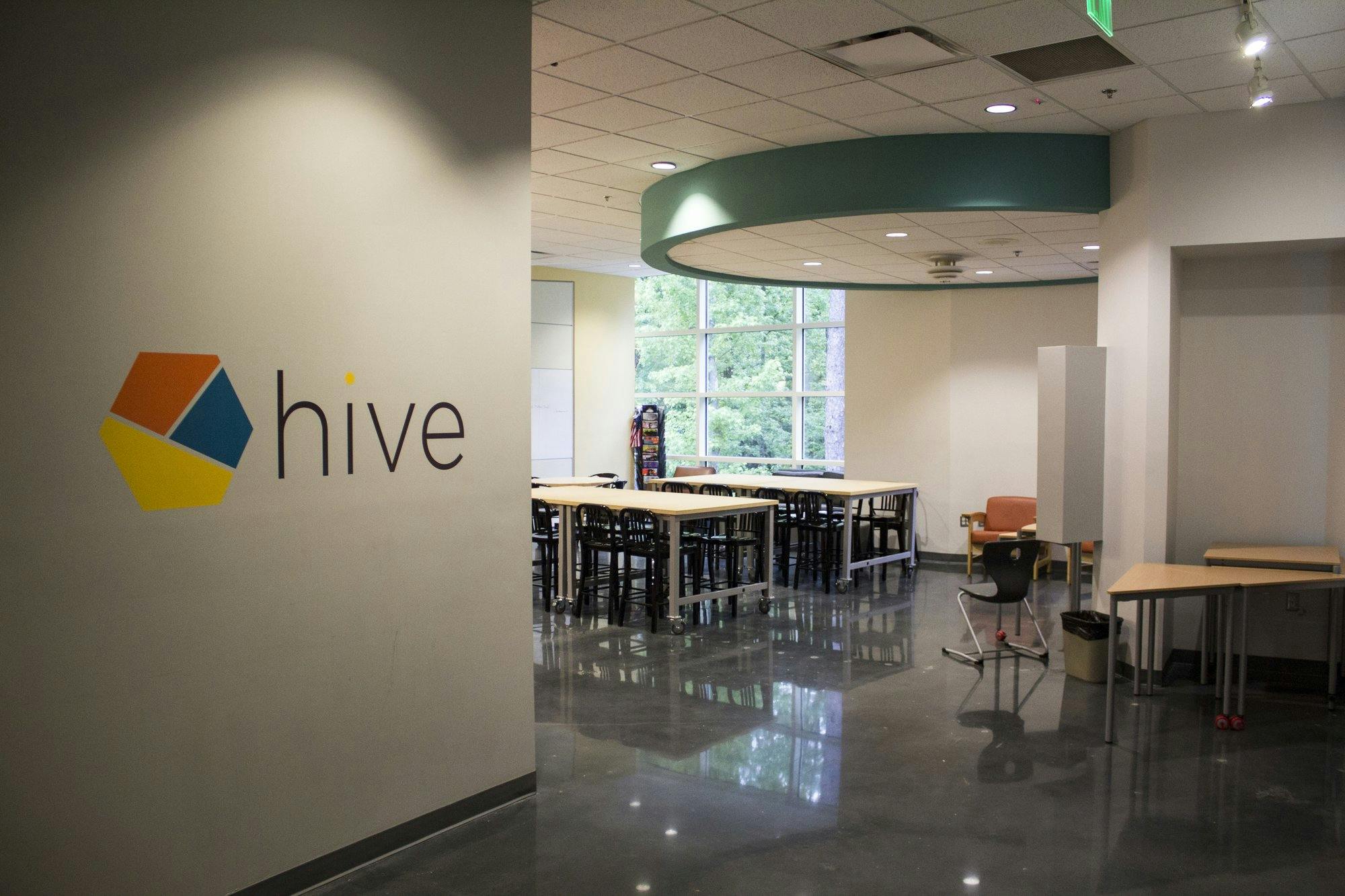 A logo with the word "hive" is printed on the wall at the front of an educational innovation space.