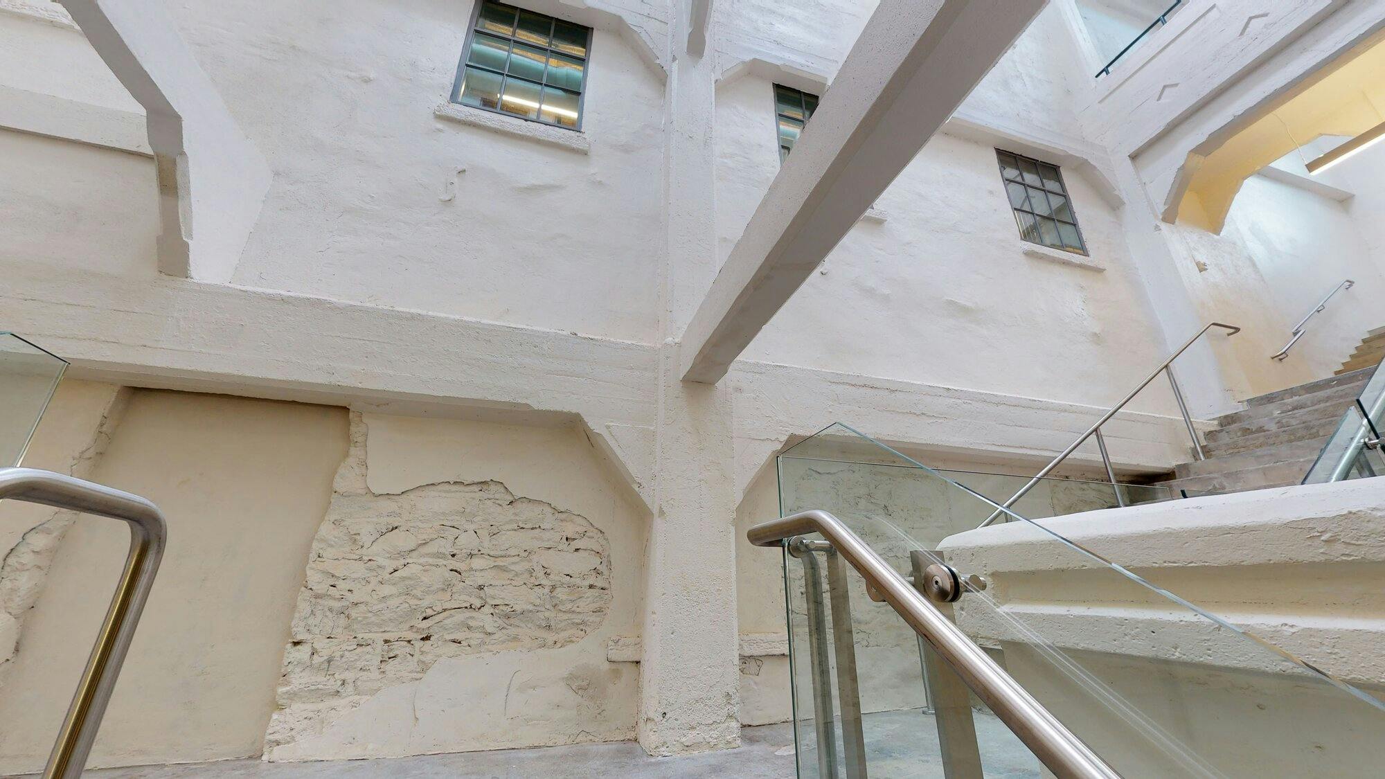 restored exposed brick facade with windows and a staircase.