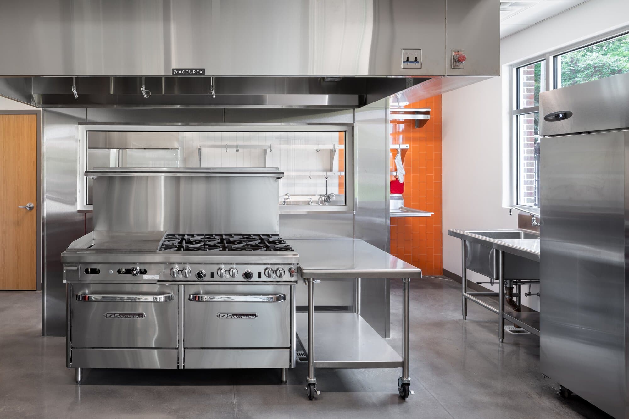 Kitchen and prep area with commercial grade kitchen appliances and counters.