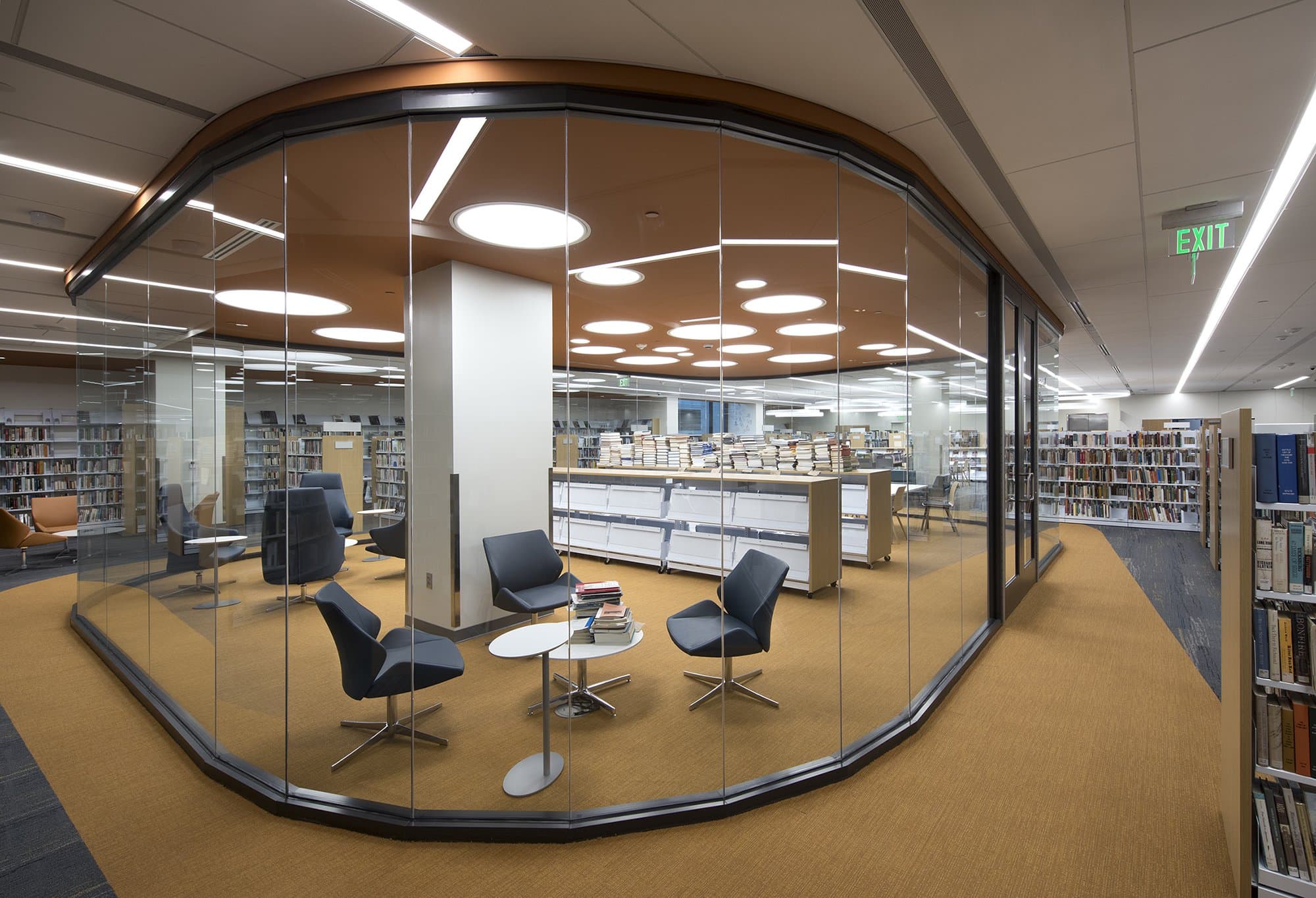 Reading area inside of library with curved glass wall around it.