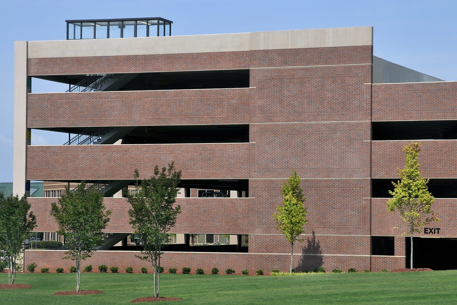 Exterior view of parking deck with grassy area beside it.