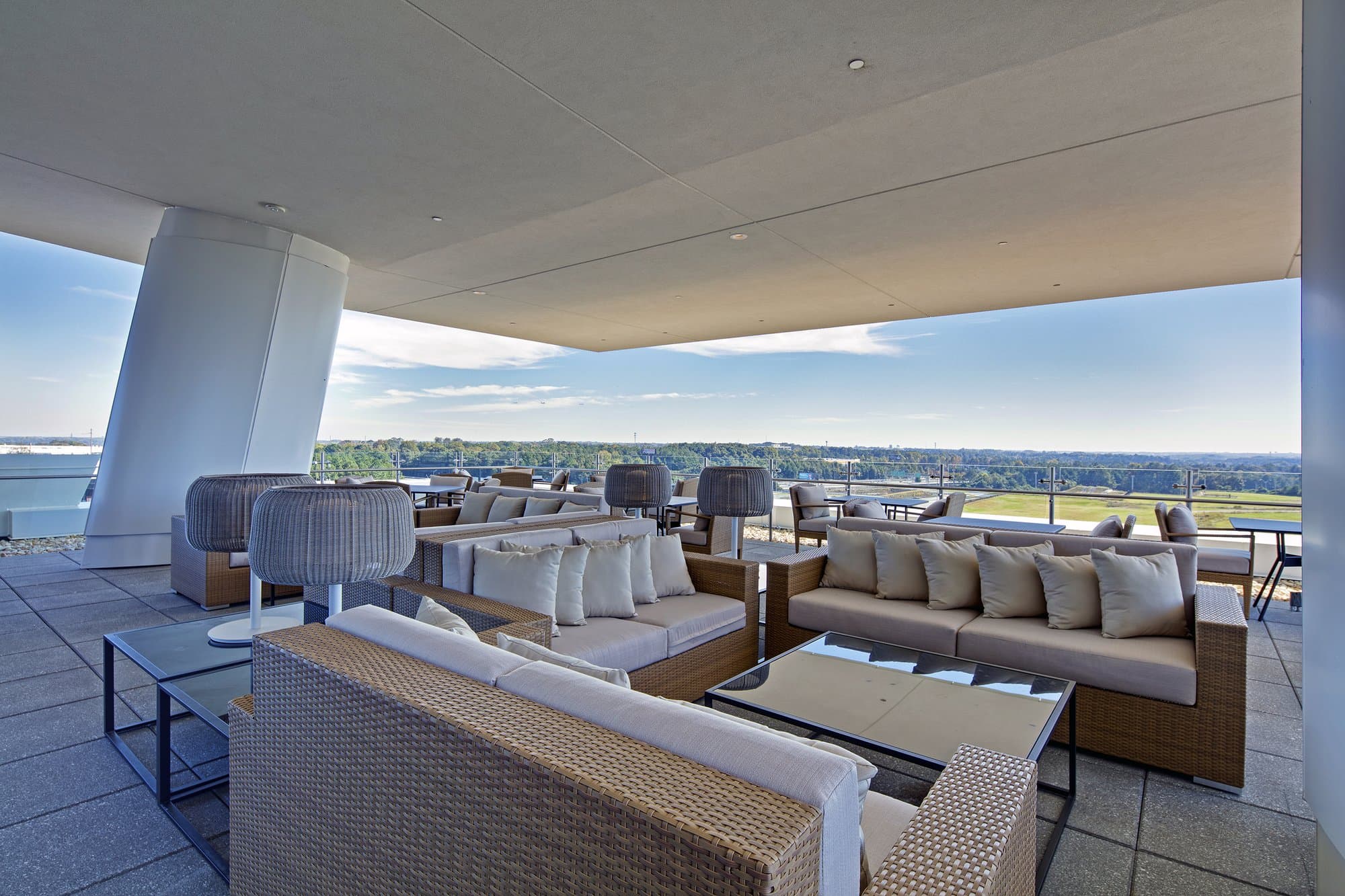 Covered rooftop terrace with comfortable cushioned seating overlooking the greenery of Atlanta.