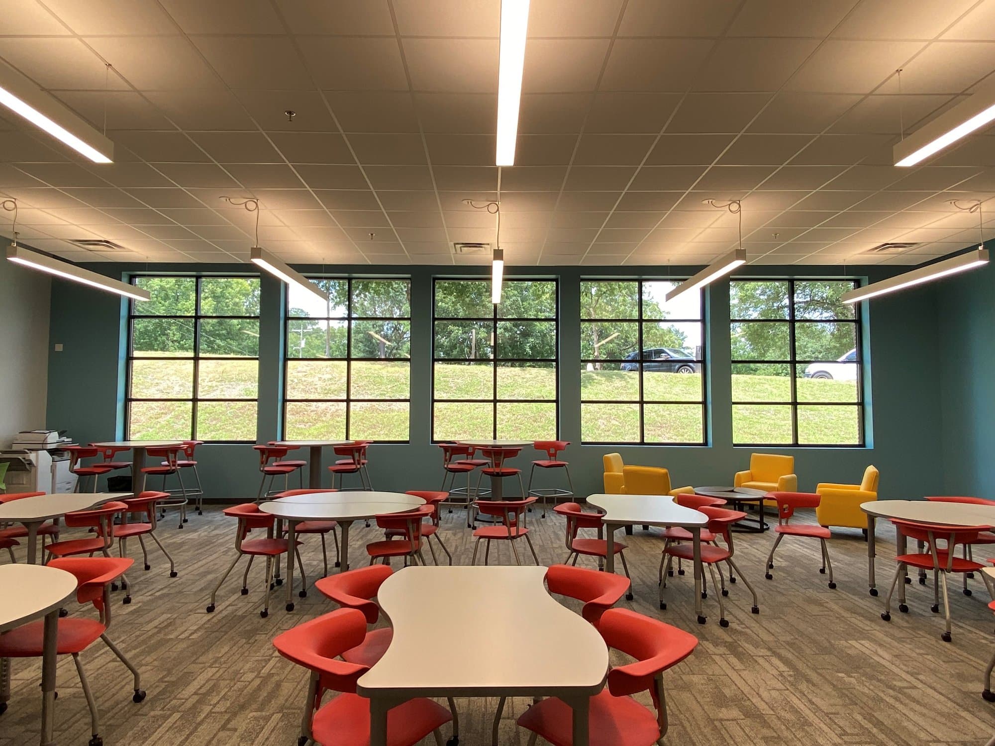 Red rolling chairs surround unconventionally shaped tables in the "innovation lab" at Landmark Christian School.