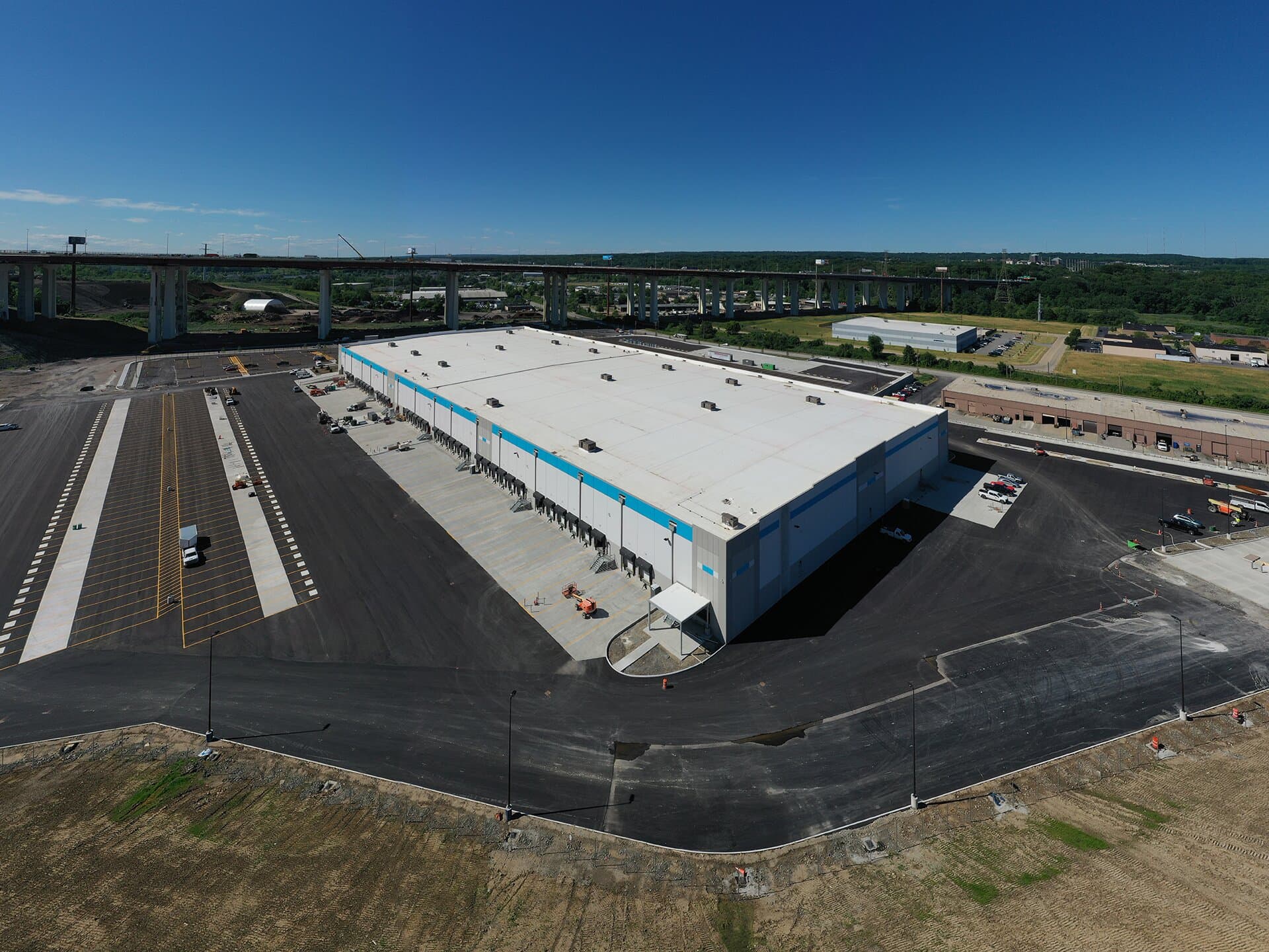 Exterior image of warehouse from above featuring bay spacing, parking lot and employee entrance/exit.