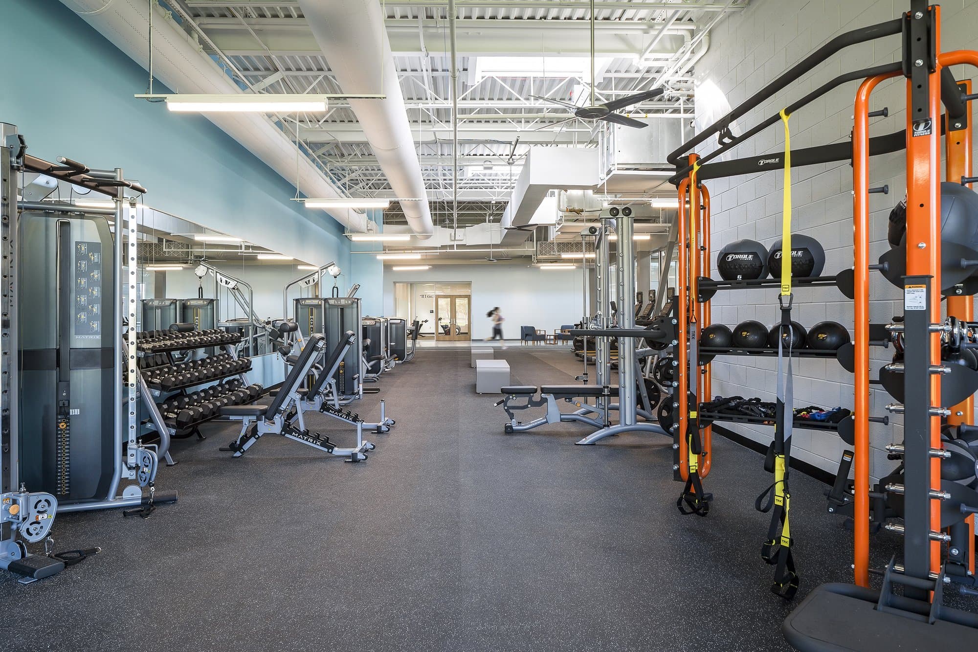 gymnasium with multiple exercise machines and lots of free weights